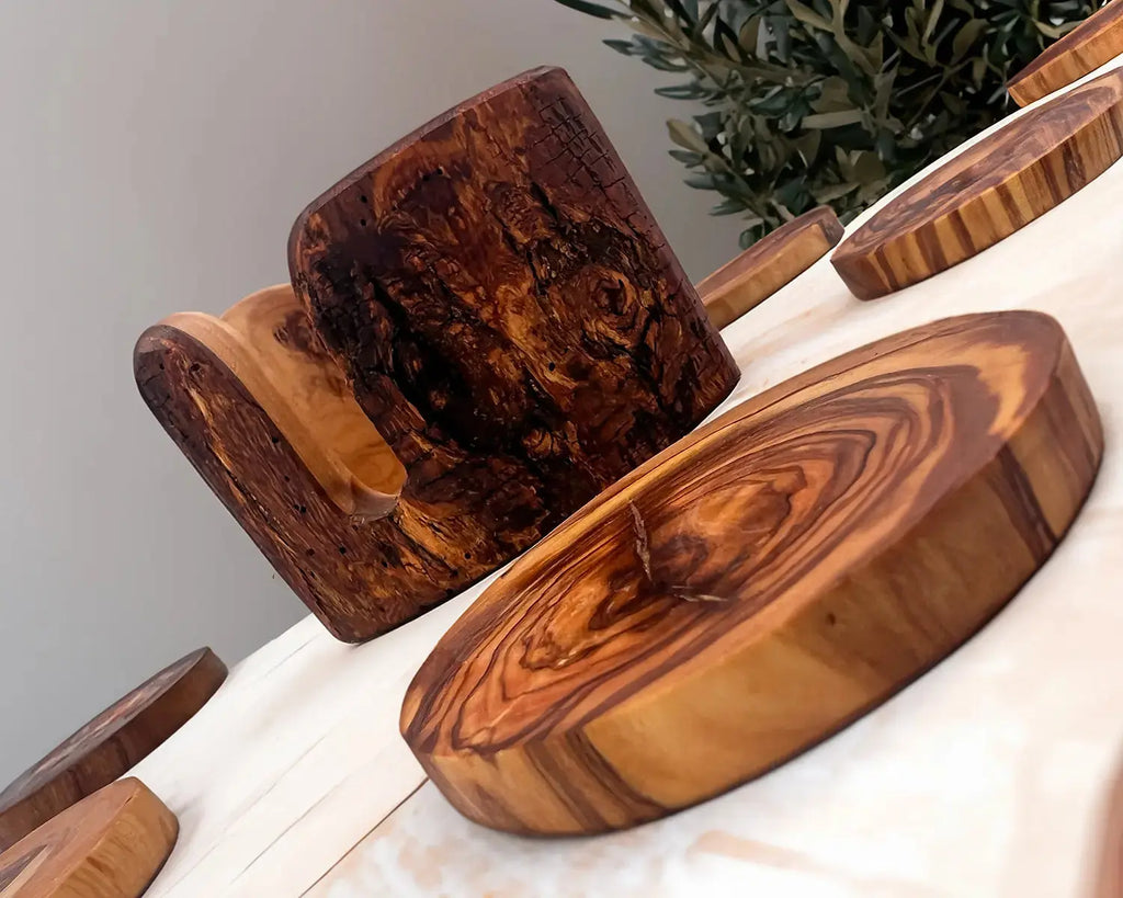 Set of wooden drink coasters made from live edge olive wood with a rustic holder. Features a vintage design with unique natural grain patterns, perfect for protecting surfaces and adding charm to table decor
